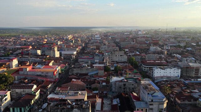 Aerial perspective of city of Iquitos in Peru, showing the urban landscape surrounded by the vast Amazon rainforest at sunset
