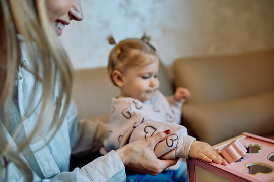 Mother and baby playing with a shape sorter toy, focusing on early childhood development, learning, and family bonding