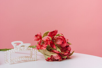 Pearl hair claw and bouquet on pink background. High quality photo