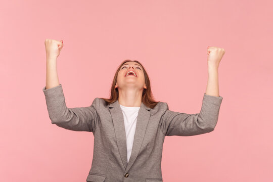Extremely happy optimistic woman with brown hair clenched fists celebrating victory being overjoyed