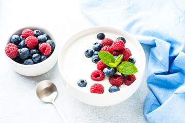 Yogurt with fresh berries in white bowl.