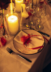 Warm candlelit banquet table with roses and crystal decor in restaurant