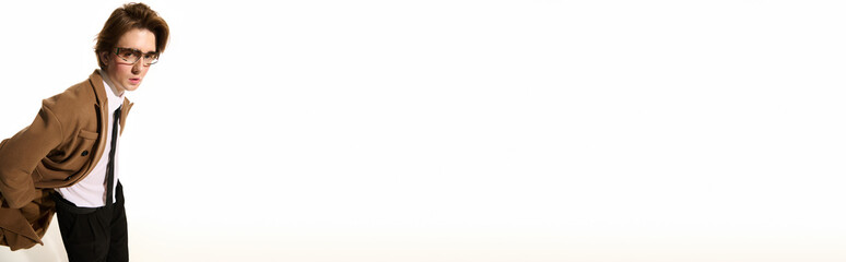 Young stylish man showcasing trendy fashion against a minimalist background