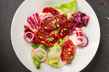 Salad sun-dried tomato green leaf lettuce, onion natural product tasty snack fresh delicious gourmet food background on the table rustic top view copy space keto and paleo diet vegan and vegan food