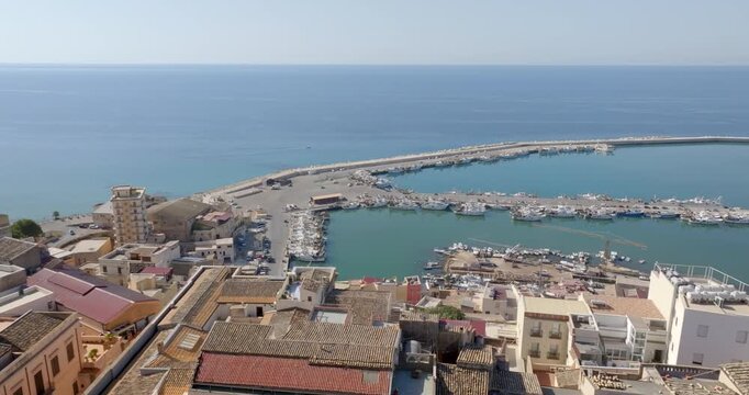 Aerial view of the port of Sciacca, in the province of Agrigento, Sicily, Italy. It is a small Sicilian town overlooking the Mediterranean Sea. The blue waters extend to the horizon.