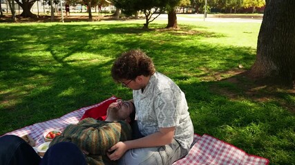 Loving gay couple having a romantic moment during a picnic on a sunny day in a beautiful park