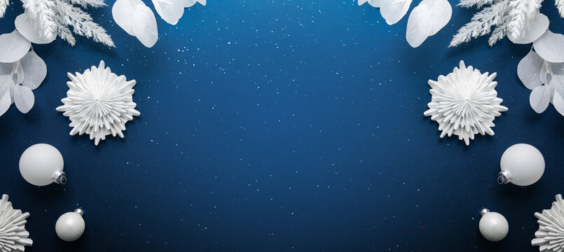 Merry Christmas and Happy Holidays greeting card, frame, banner. New Year. Noel. White Christmas ornaments on blue background top view. Winter xmas holiday festive theme.