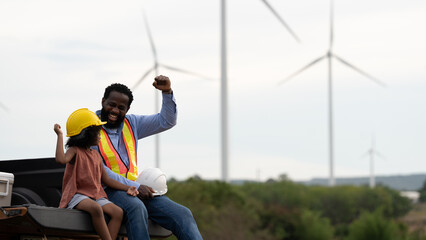 Engineer father and daughter celebrating at wind turbine site, raising fists with joy, symbolizing success, renewable energy pride, family bonding, STEM future, and clean energy inspiration.