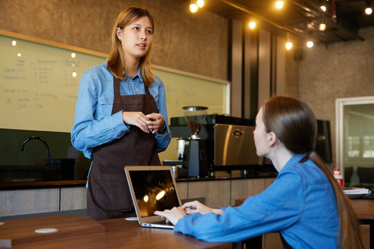 young barista meeting and talking about work in the cafe