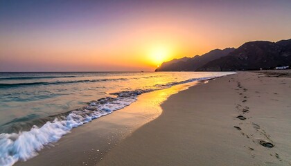 A serene beach scene at sunset with waves gently lapping onto the sandy shore, mountains in the background