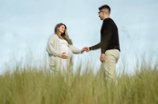 mulher gr&aacute;vida segurando a m&atilde;o do seu marido