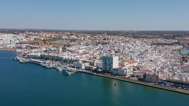 Aerial view drone shot of Ayamonte golden hour aerial view ayamonte marina with warm light on white buildings, quay and moored boats, waterfront cafes and terraces, reflections on Guadiana