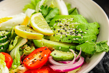 Avocado salad egg, tomato, onion, green leaf salad vegetable dish natural tasty snack fresh gourmet food background on the table rustic top view copy space keto and paleo diet vegan and vegan food