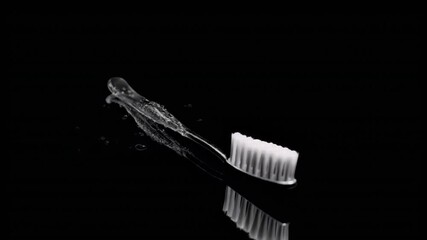 Tooth dental health concept. toothbrush with water splash on black surface. - Powered by Adobe