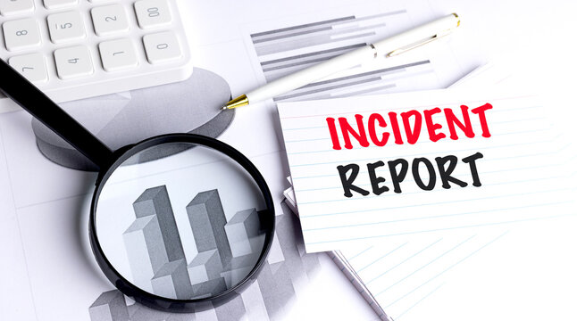 Incident report message on lined card with magnifying glass, pen, charts and calculator symbolizing workplace