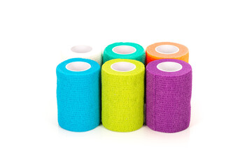 A vibrant set of multicolored self-adhesive bandage rolls displayed on a clean white background. Ideal for medical, sports, first aid, veterinary care, and healthcare supply concepts.