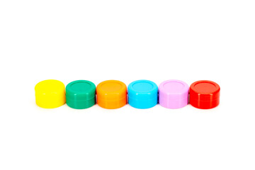 A row of colorful plastic storage containers arranged side by side on a clean white background. Vibrant lids in yellow, green, orange, cyan, purple, and red ideal for product, retail, and packaging co