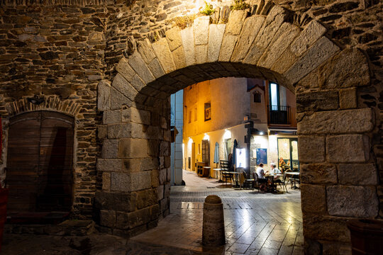 Panoramic view of colourful Collioure at night, narrow streets and yellow, pink, orange houses, historical buidings and beaches, Pyrenees-Orientales, France