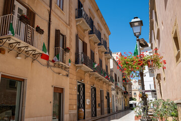 Views of Marsala, seaside Sicilian city with famous Marsala wine, old narrow streets, houses and shadow trees, fountains, vacation destination in Italy