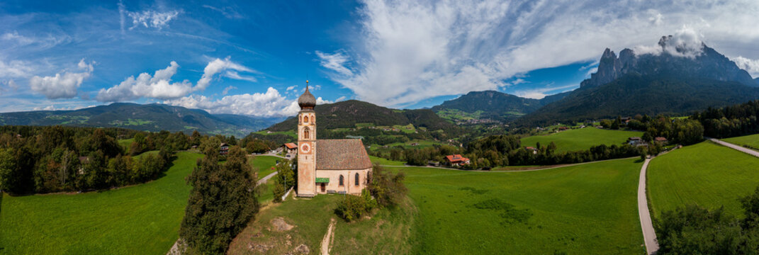 Aerial view of the St. Valentine Church in front of the Schlern massif above Seis in South Tyrol, Italy.