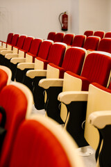 Empty auditorium seats with rows of red chairs