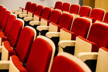 Empty red auditorium seats lining up in rows