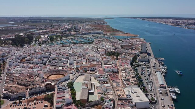 Aerial view drone shot of Ayamonte Aerial view historic center and river channel with bullring, narrow alleys, tiled roofs, seafront ramparts and long estuary stretching inland.