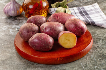 Raw red organic potato over board