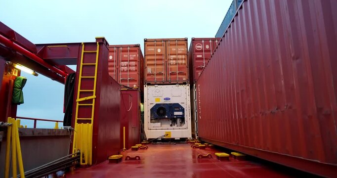 Endless rows of cargo containers align under open sky. Metal colors form geometric rhythm of global trade and motion. Cargo terminal