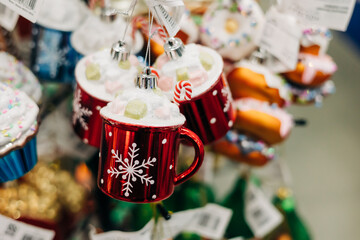 Colorful holiday decorations featuring red mugs with snowflakes and festive toppings on display