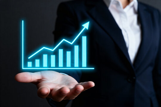 Businesswoman presenting a glowing blue growth chart on her open palm with dark background and suit