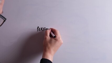 An HR business professional is writing Performance Management on a whiteboard in black marker pen, ideal for HR, recruitment, and business workplace presentations.