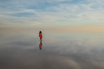 Tuz Lake, located in Ankara province of T&uuml;rkiye, has a wonderful view at sunset. Visitors walking in the shallow waters of the lake watch the sunset by taking photos or taking pictures.
