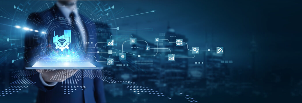 Businessman analyzing using tab data on Industry 4.0. Smart manufacturing, automation systems, IoT integration, robotics, and digital industrial transformation.