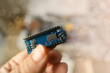 scientist, electronic engineer holds electronic chip, bug, microcontrollers in hand, Electronics components, circuit building, electrical engineering, neural implants, Neurotechnology Advancements