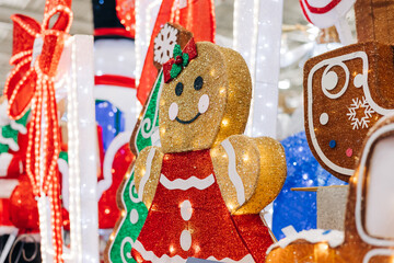Festive gingerbread decoration lights up holiday display in a busy shopping center during winter season