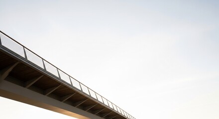 Obraz premium A modern pedestrian bridge railing against a pale sky