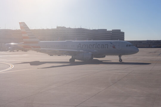 PHOENIX, ARIZONA, USA, NOVEMBER 09, 2025: An American Airlines Airbus A320 series aircraft is seen on the tarmac at Phoenix Sky Harbor International Airport (PHX) with the airport parking garage or te