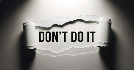 Don't do it text revealed through torn paper with dramatic spotlight