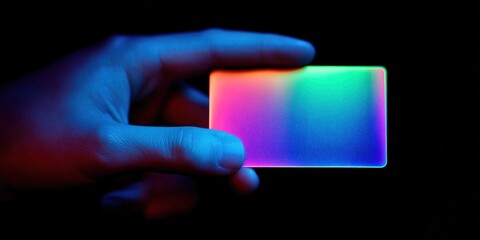 Colorful translucent card held in hand against dark background creates an eye-catching glow