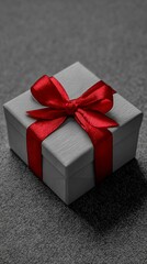 Black and white photo of detailed gift box with red ribbon