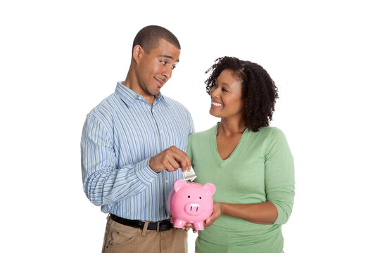 Man putting money into piggy bank held by woman, smiling