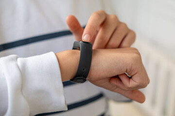 young teenager checking smart watch on wrist, child interacts with smartwatch, fitness band, trend wearable technology monitoring kids' daily activity and promoting healthy habits, activity tracker