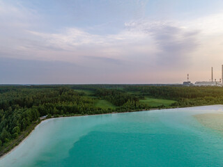 Aerial sunset view of Auvere Power Plant Settlement Basin in Ida-Viru County, Estonia. Turquoise ash pond and industrial chimneys create a striking contrast. Landmark of region energy