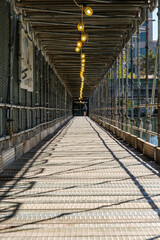 Protective scaffolding for pedestrians with lighting along a river in Indianapolis, Indiana