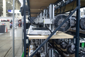 Many 3D printers printing an object. 3D printers simultaneously printing model from molten plastic. Many 3D printers creating shape from molten plastic flowing out of extruder. 3D printing technology