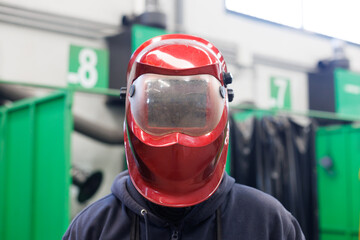 Welder wearing safety helmet in industrial workshop