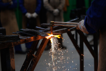 Artisan worker cutting metal with oxy-fuel torch