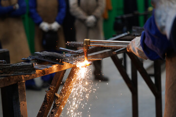 Artisan worker welding metal with cutting torch