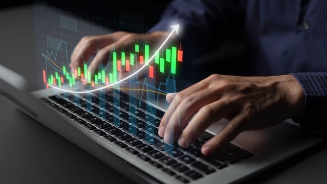 A close-up of hands typing on a laptop, showcasing digital stock market graphs that reflect financial growth and data analysis in a contemporary business setting. Copula - Powered by Adobe